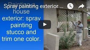 Spray painting exterior stucco house. 