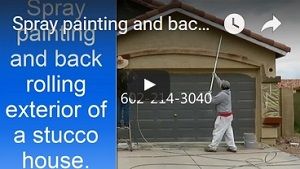 Spray painting and back rolling stucco house
